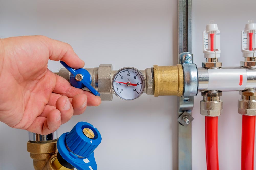 Instant tankless electric water heater installed on grey tile wall with input and output pipe outlet and elcb safety breaker system and silver shower